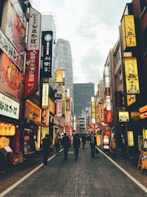 Scenic view of a bustling Japanese street with neon signs and people commuting.