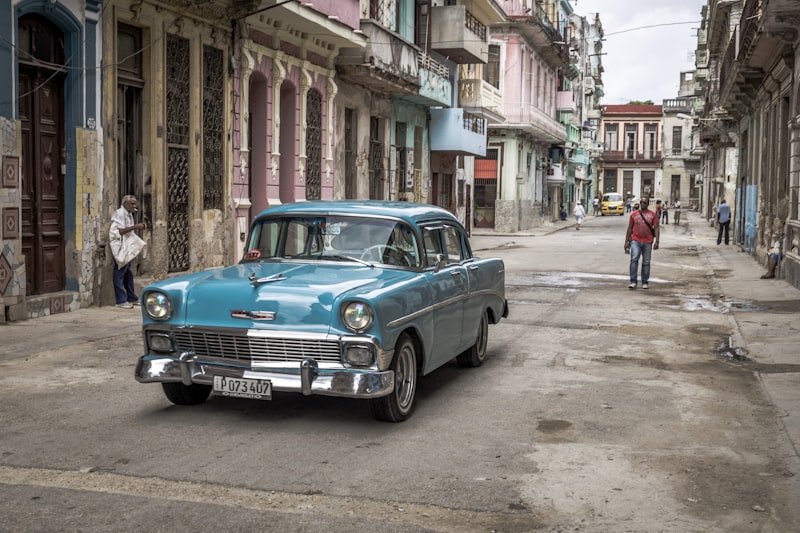 Coche clásico verde junto a edificio colonial en La Habana Vieja, Cuba — zona de escuelas y universidades