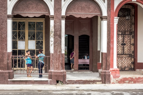2 women standing in front of brown wooden door in Habana Cuba