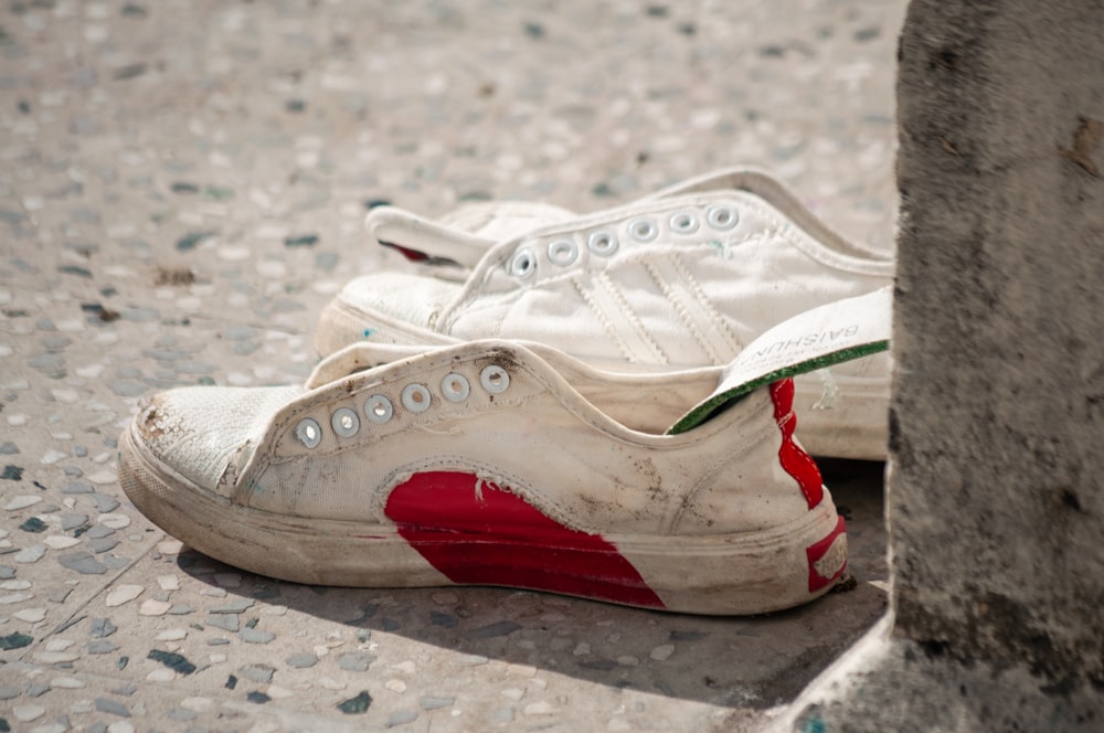 a pair of white and red shoes sitting on the ground