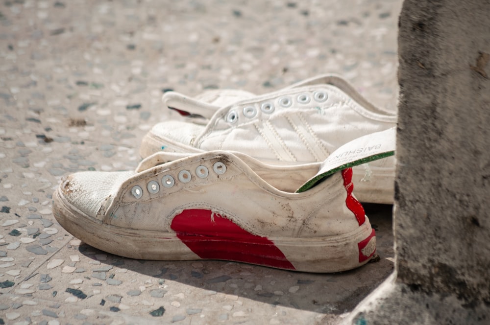 une paire de chaussures blanches et rouges posées par terre