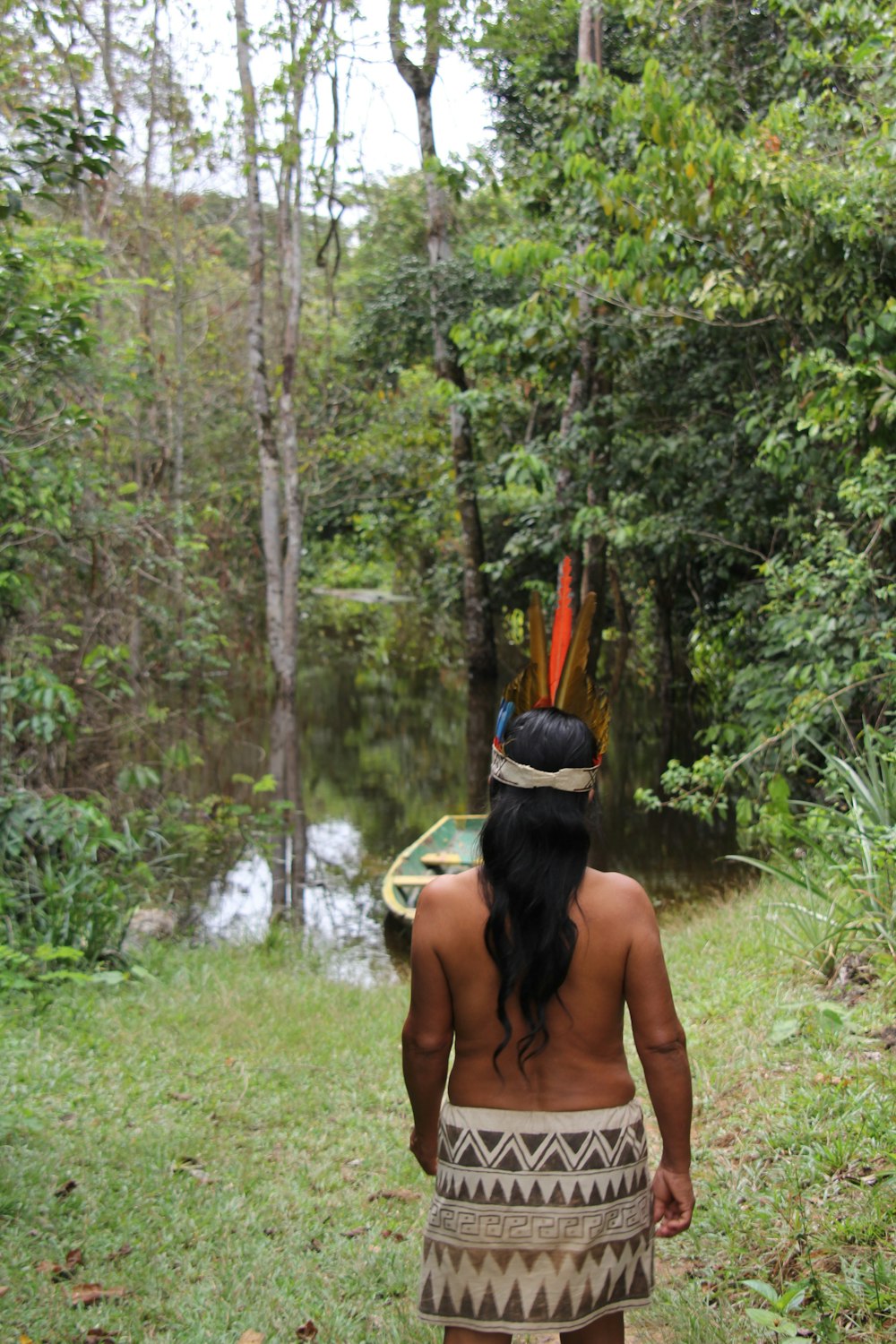 mulher na regata preta e tampa de malha amarela em pé no campo verde da grama durante o dia