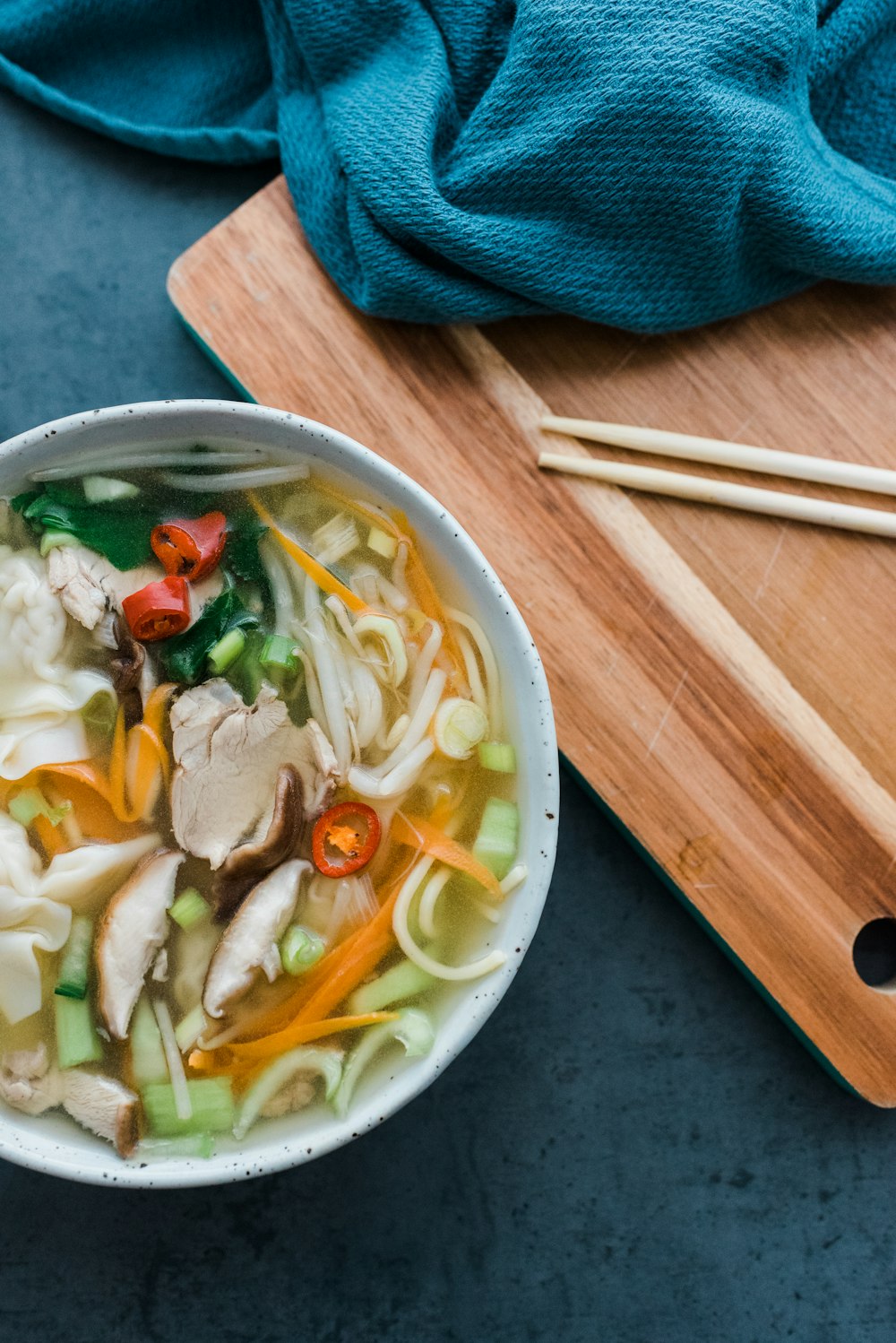 white soup with sliced carrots and onions in white ceramic bowl