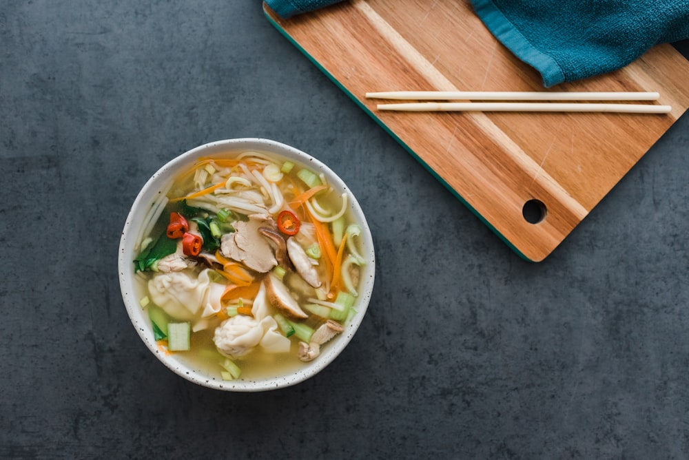 white ceramic bowl with brown wooden chopsticks