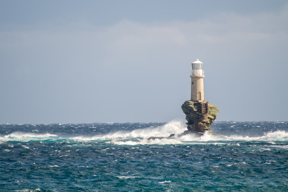 white and brown lighthouse on ocean water during daytime