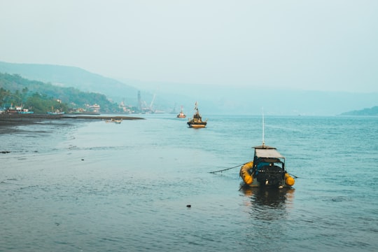 yellow and black auto rickshaw on body of water during daytime in Guhagar India