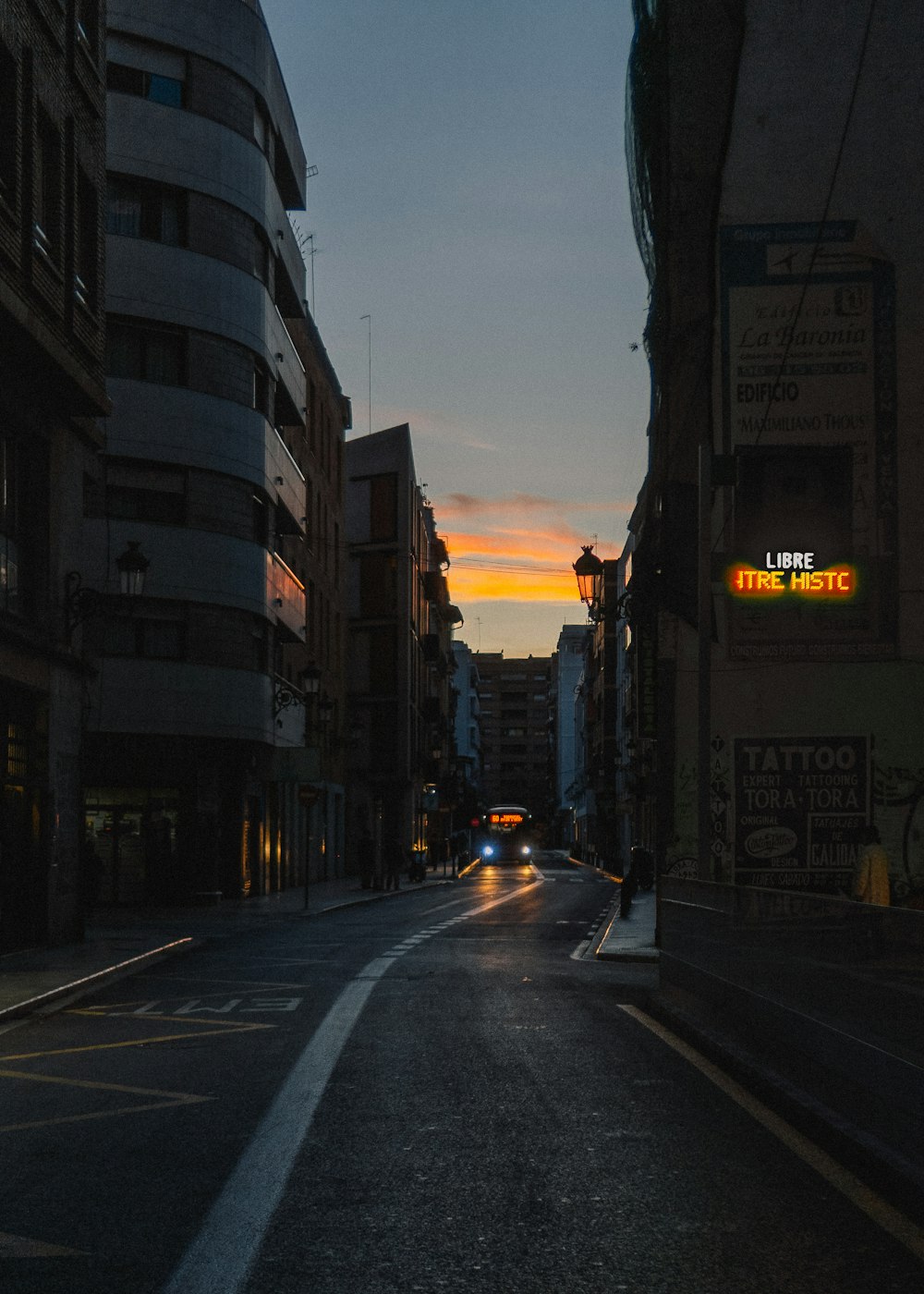 cars on road between high rise buildings during daytime