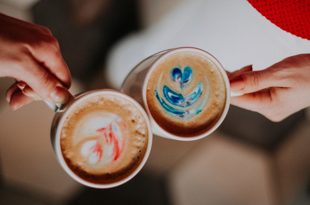 白い陶器のマグカップとコーヒーを持っている人