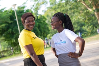 A friendly community worker assisting a smiling informal worker outdoors