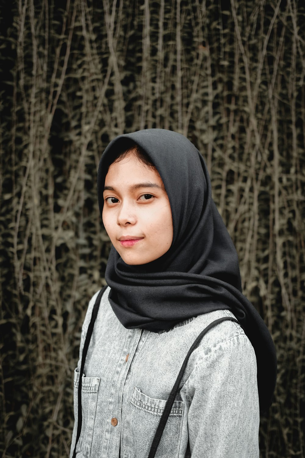 woman in black hijab standing near trees