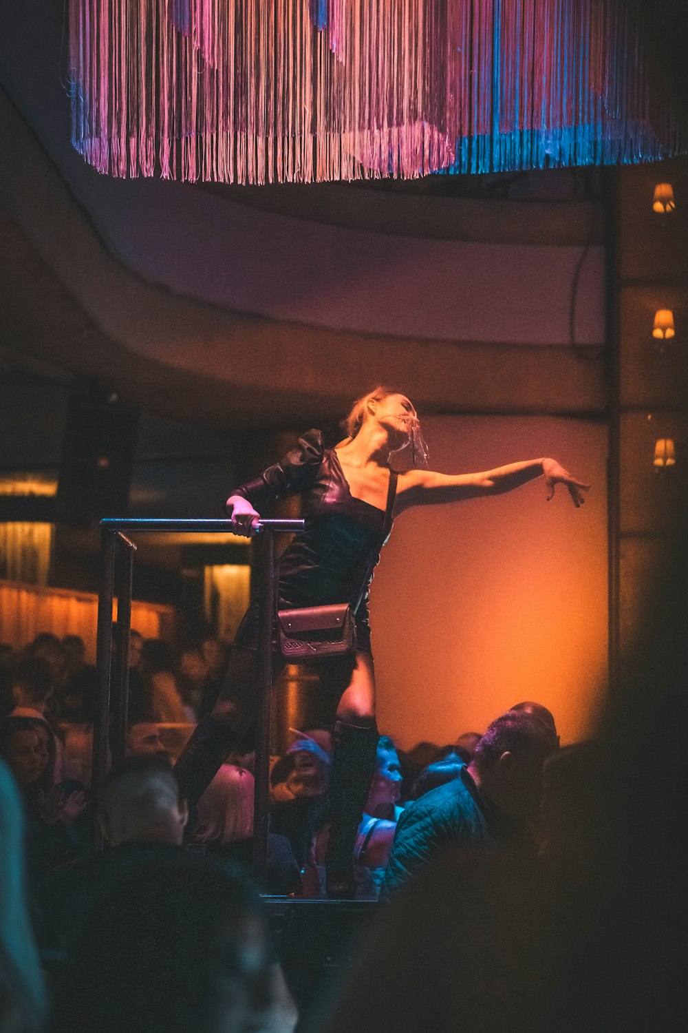 woman in black sleeveless dress singing on stage