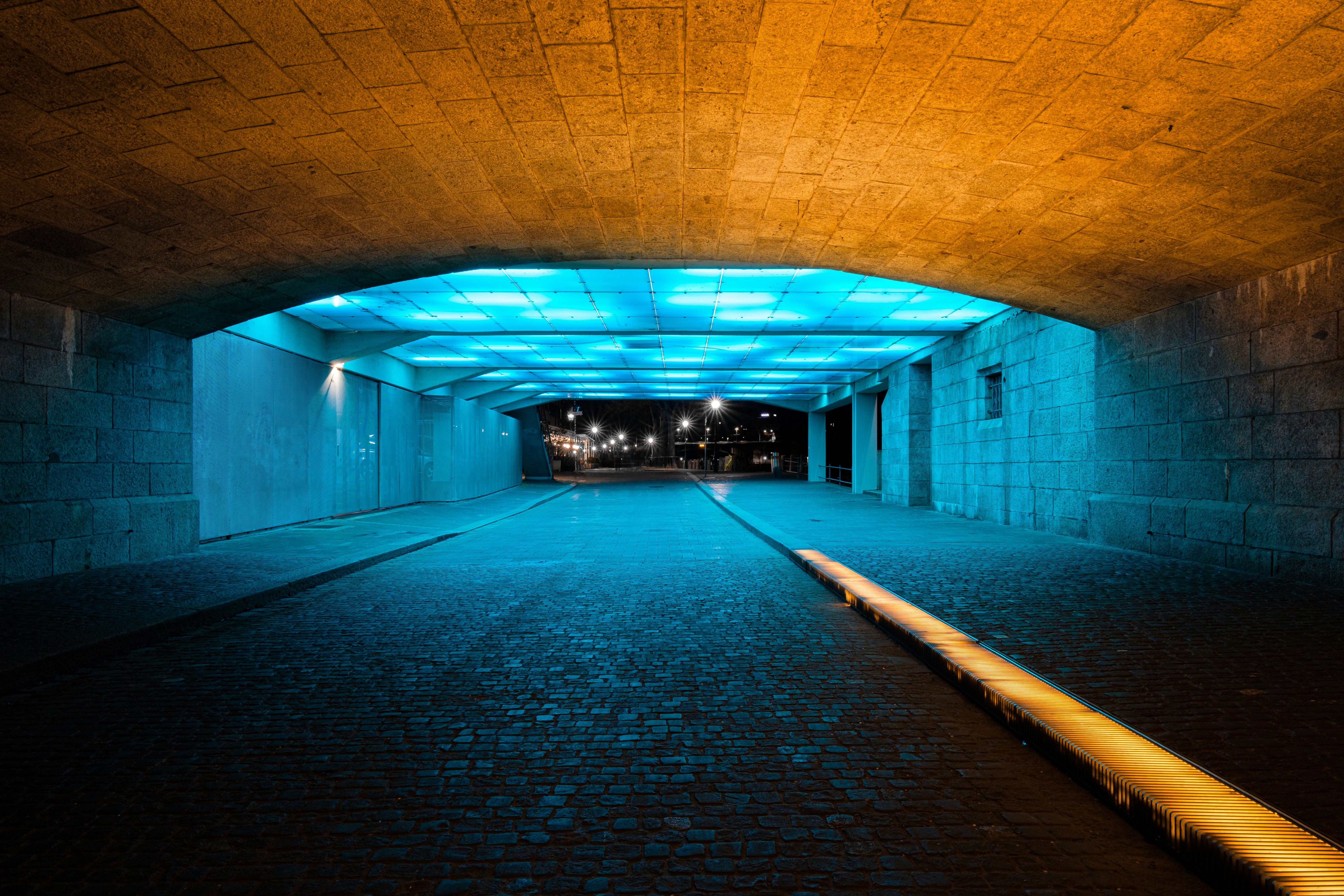 brown and black tunnel with lights turned on during night time