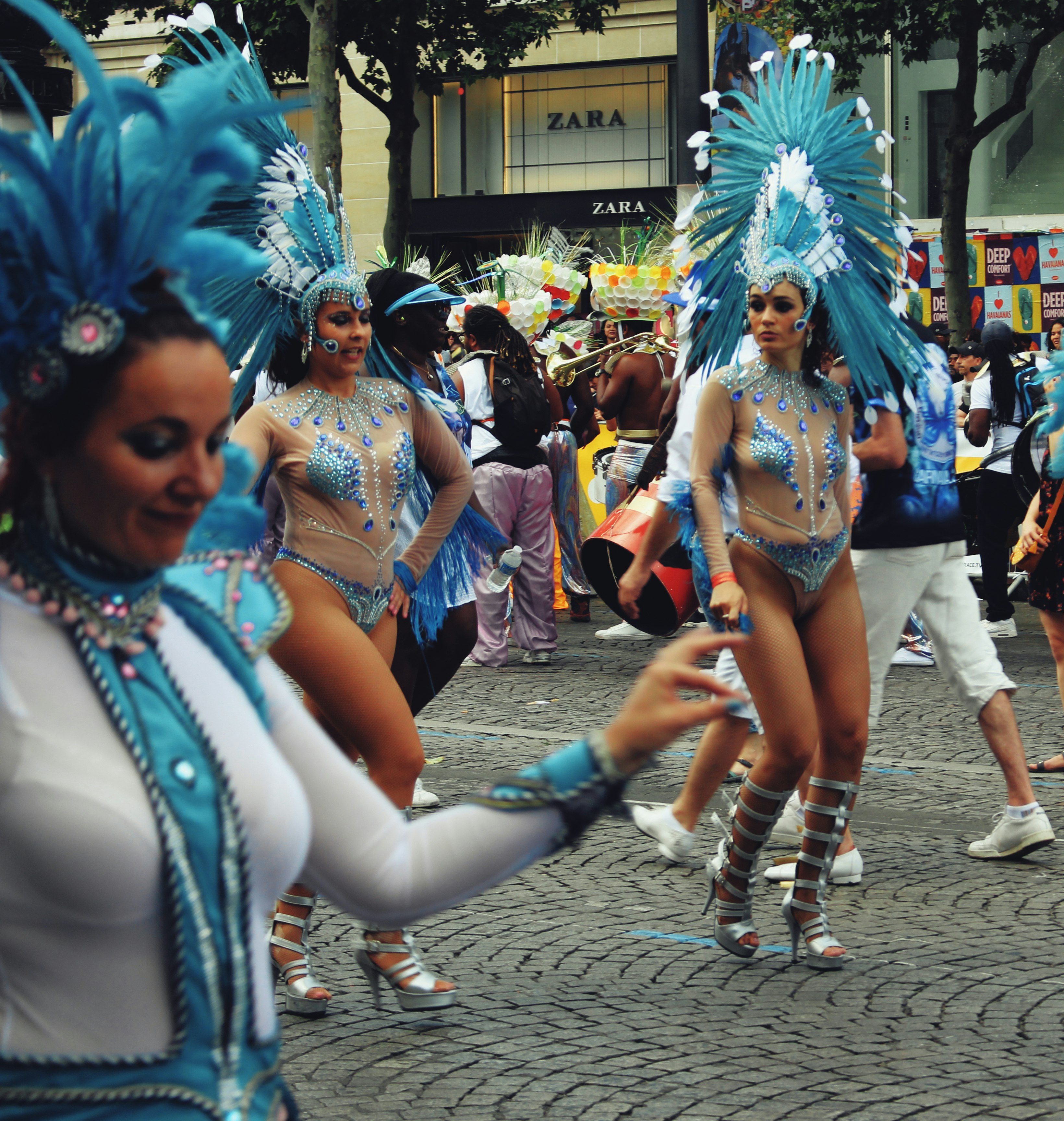 woman in blue and white feather costume standing on gray concrete floor during daytime