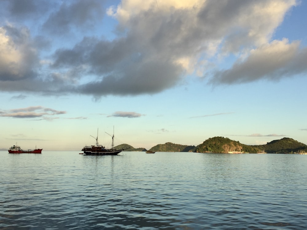 boat on sea under cloudy sky during daytime