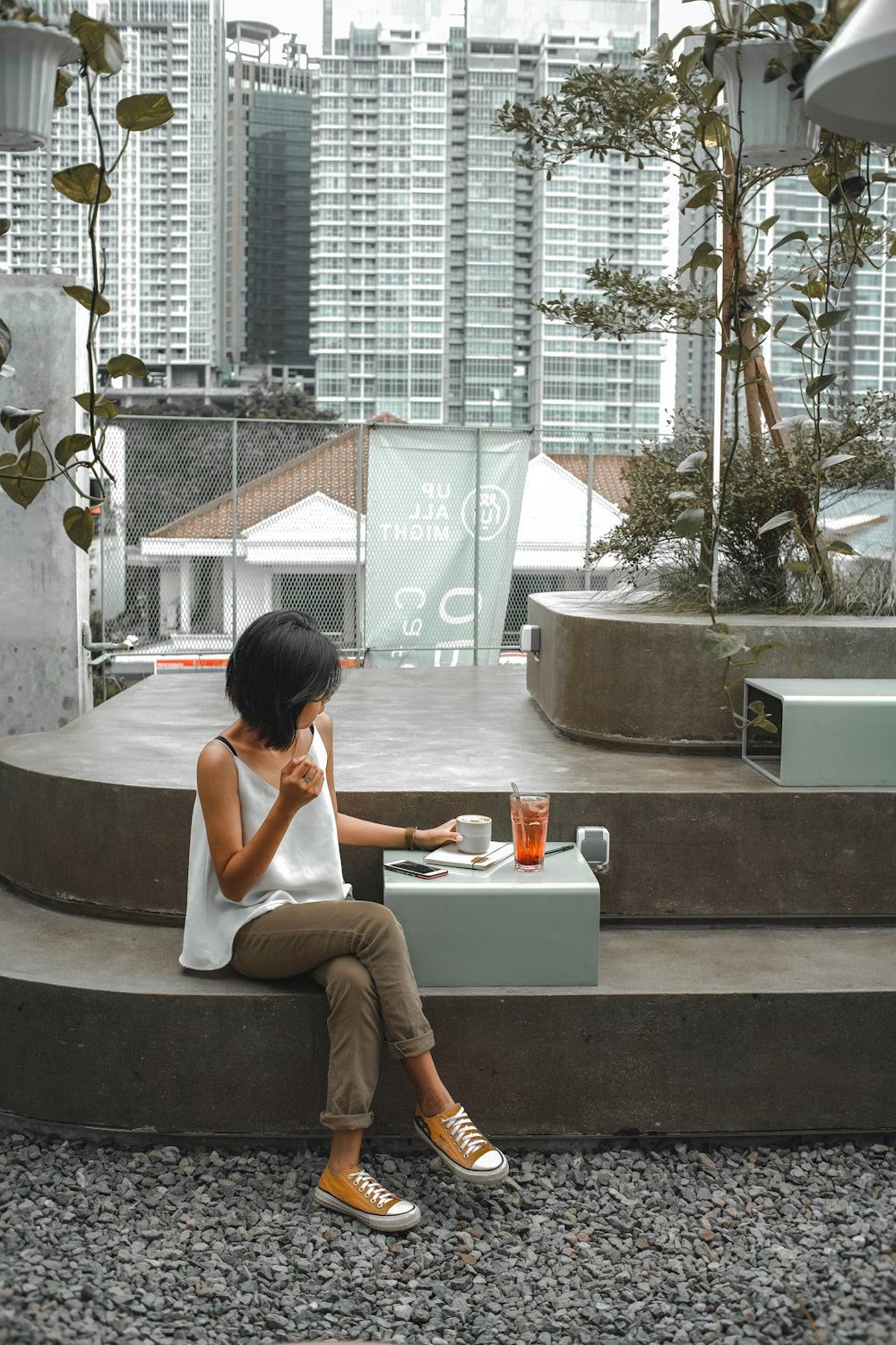 woman in white shirt sitting on gray concrete bench