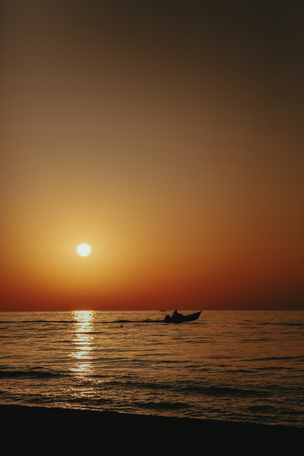 silhouette of person riding on boat during sunset