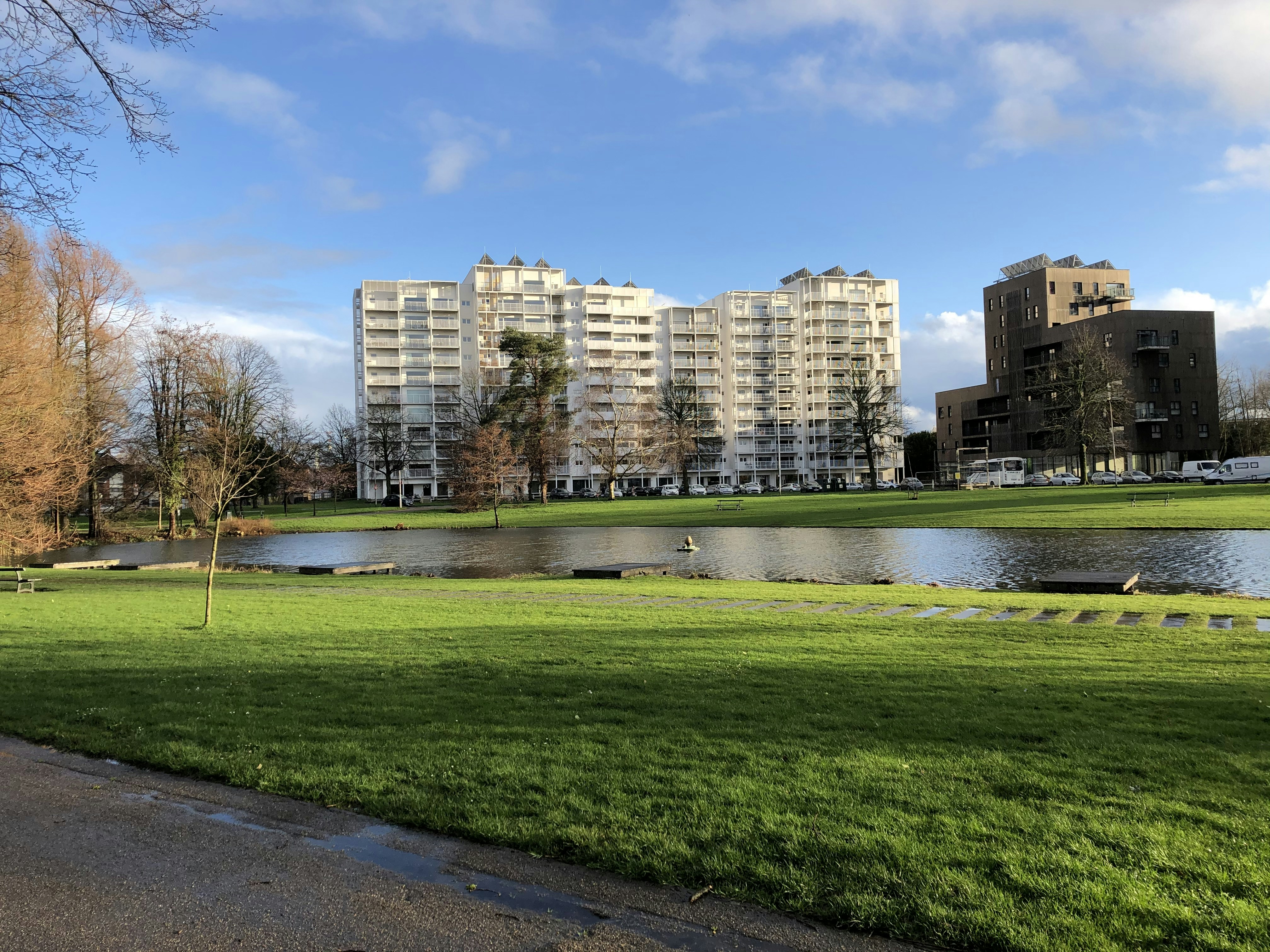 Champ d’herbe verte près des bâtiments de la ville sous le ciel bleu pendant la journée