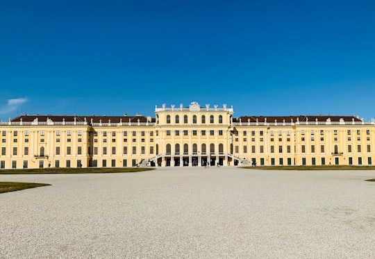 white concrete building under blue sky during daytime in Schönbrunn Palace Austria