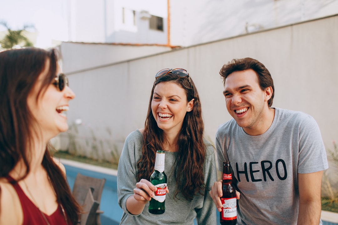 smiling woman holding coca cola bottle beside smiling woman holding coca cola bottle