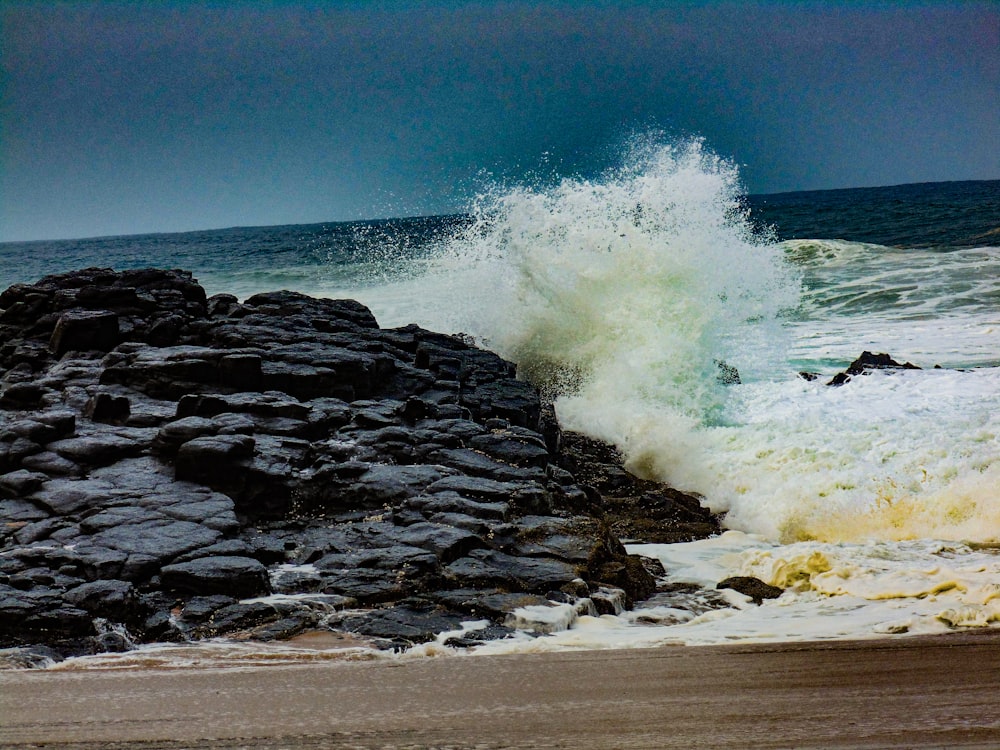 Les vagues de la mer s’écrasent sur les rochers pendant la journée