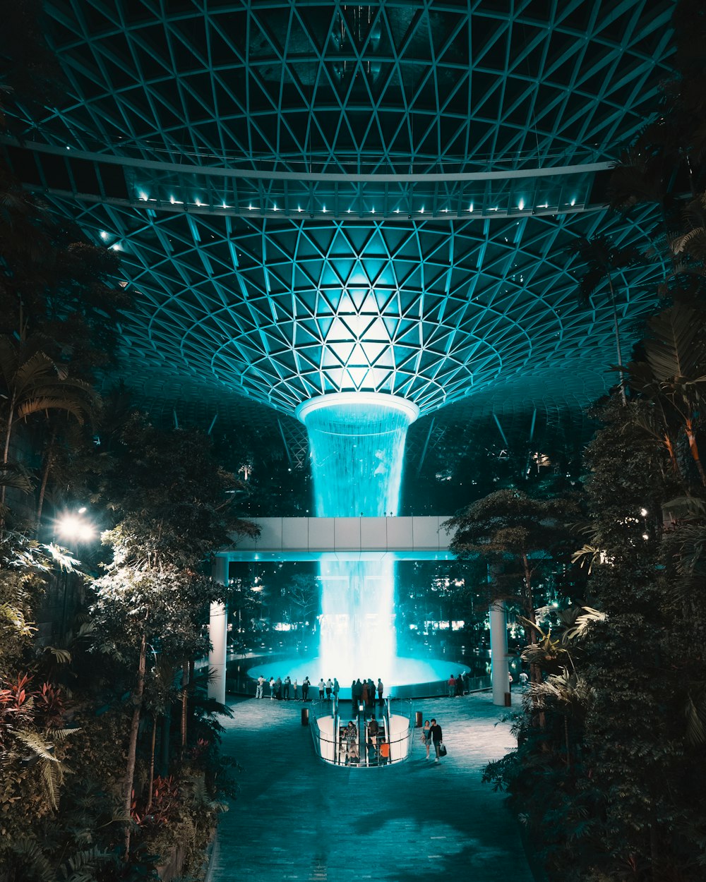 people walking on pathway with lights turned on during night time