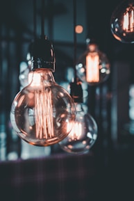 clear glass light bulb turned on in tilt shift lens
