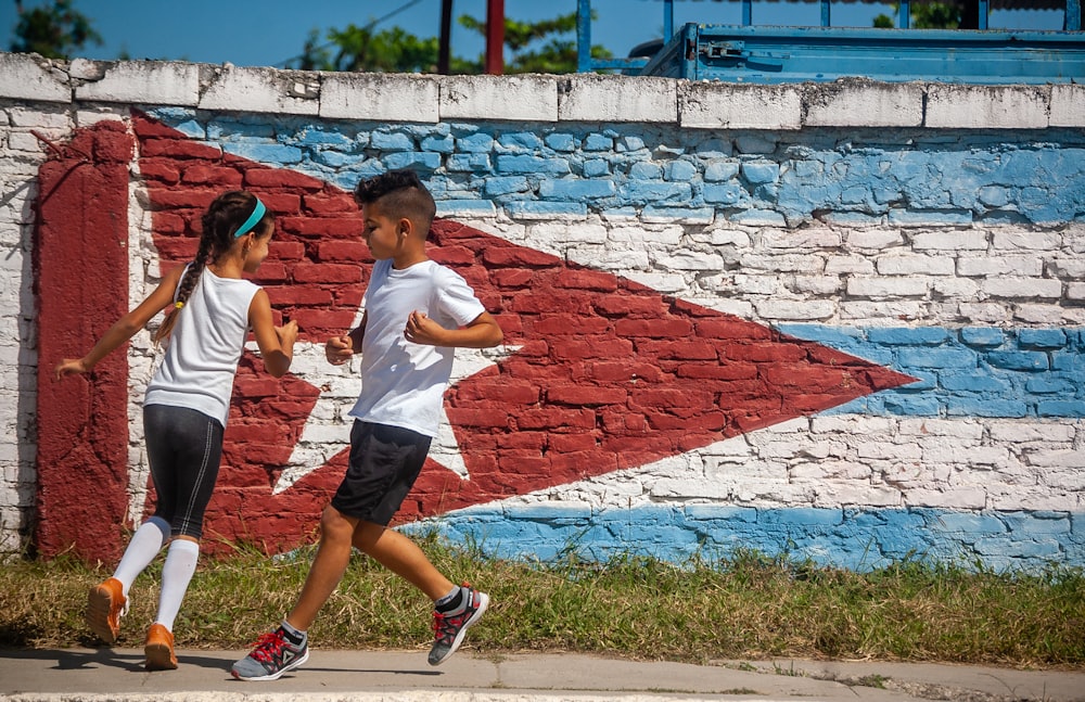 man in white t-shirt and black shorts holding girl in white t-shirt