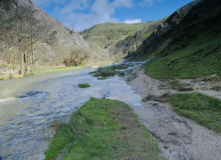 A serene blue-hued landscape of a national park with a winding trail under a clear sky.