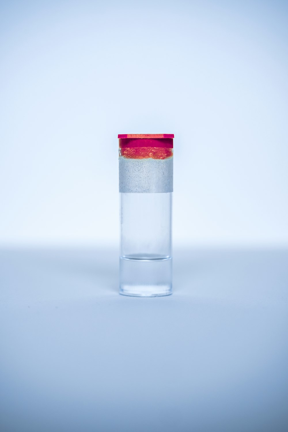 赤いふたが付いている透明なガラス瓶