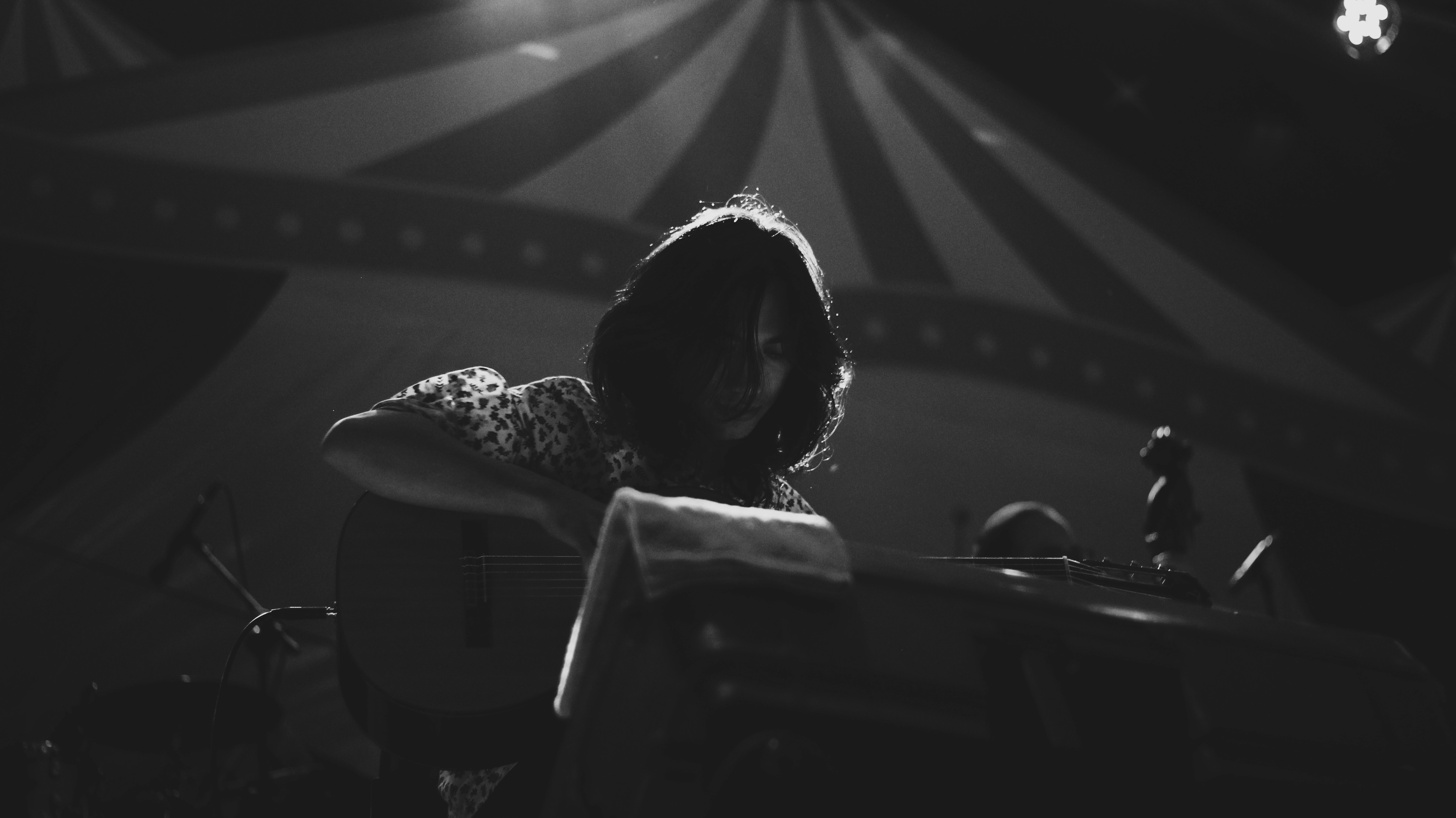 A vintage black and white still of a carnival performer playing guitar.