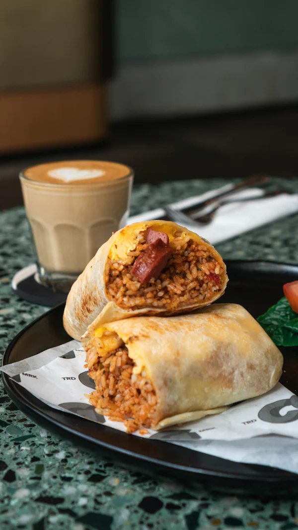 Burrito with red salsa and a drink