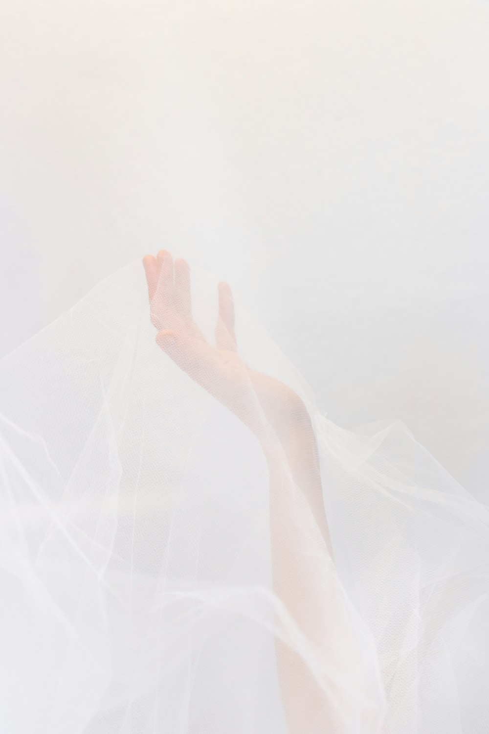 persons hand on white textile