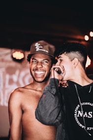 man in black fitted cap and topless man