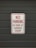 A white sign with red text that reads 'No Parking in Front of Garage Door' is mounted on a dark gray garage door.