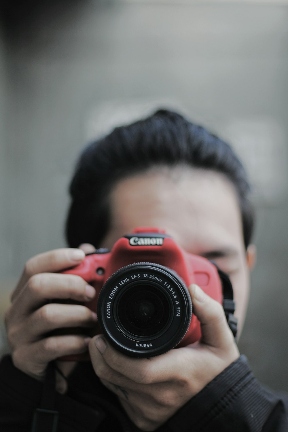 person holding red nikon dslr camera