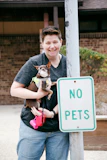 woman in black tank top carrying white and brown chihuahua puppy