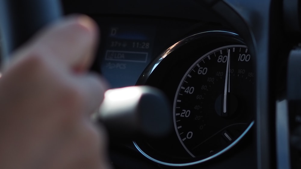 person holding white and black car gear shift lever