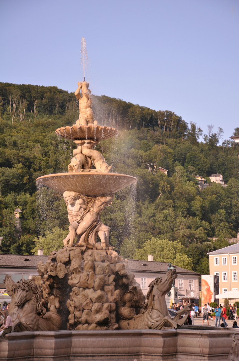 Brauner Betonbrunnen in der Nähe von grünen Bäumen tagsüber