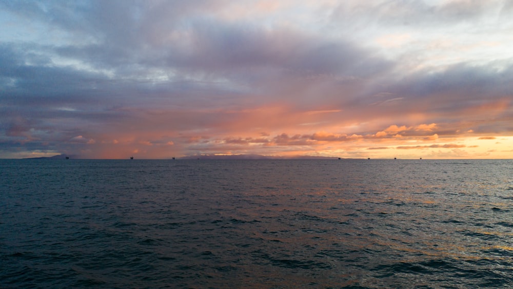 body of water under cloudy sky during daytime