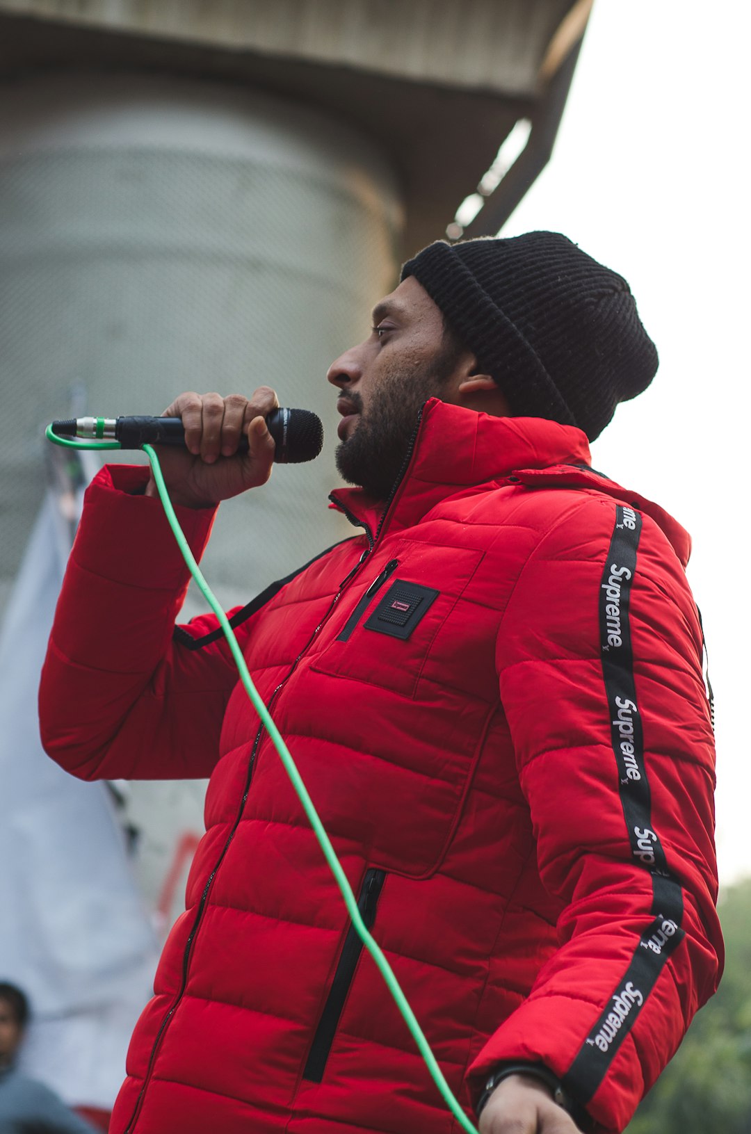 man in red jacket holding microphone