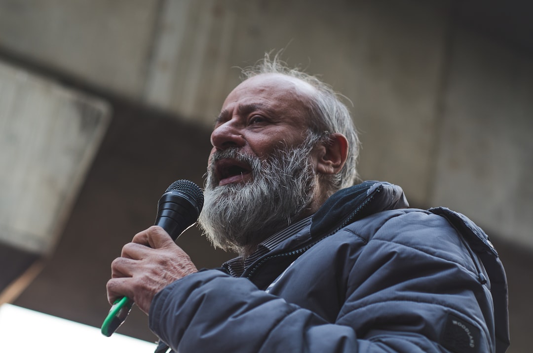 man in blue jacket holding microphone