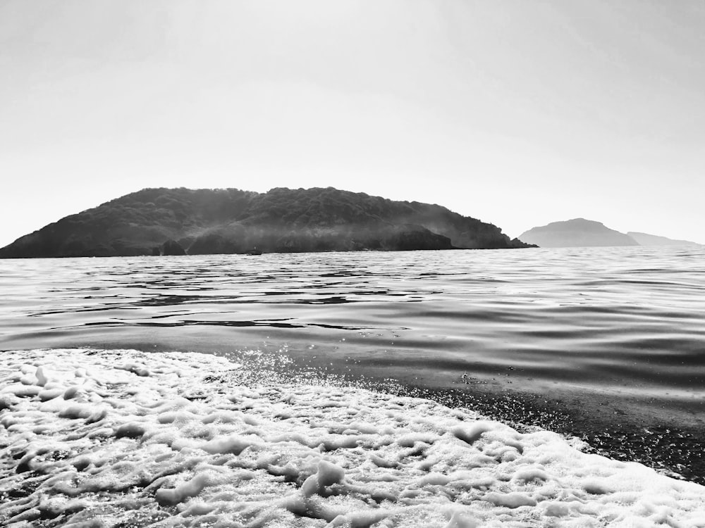 grayscale photo of sea waves crashing on rocks