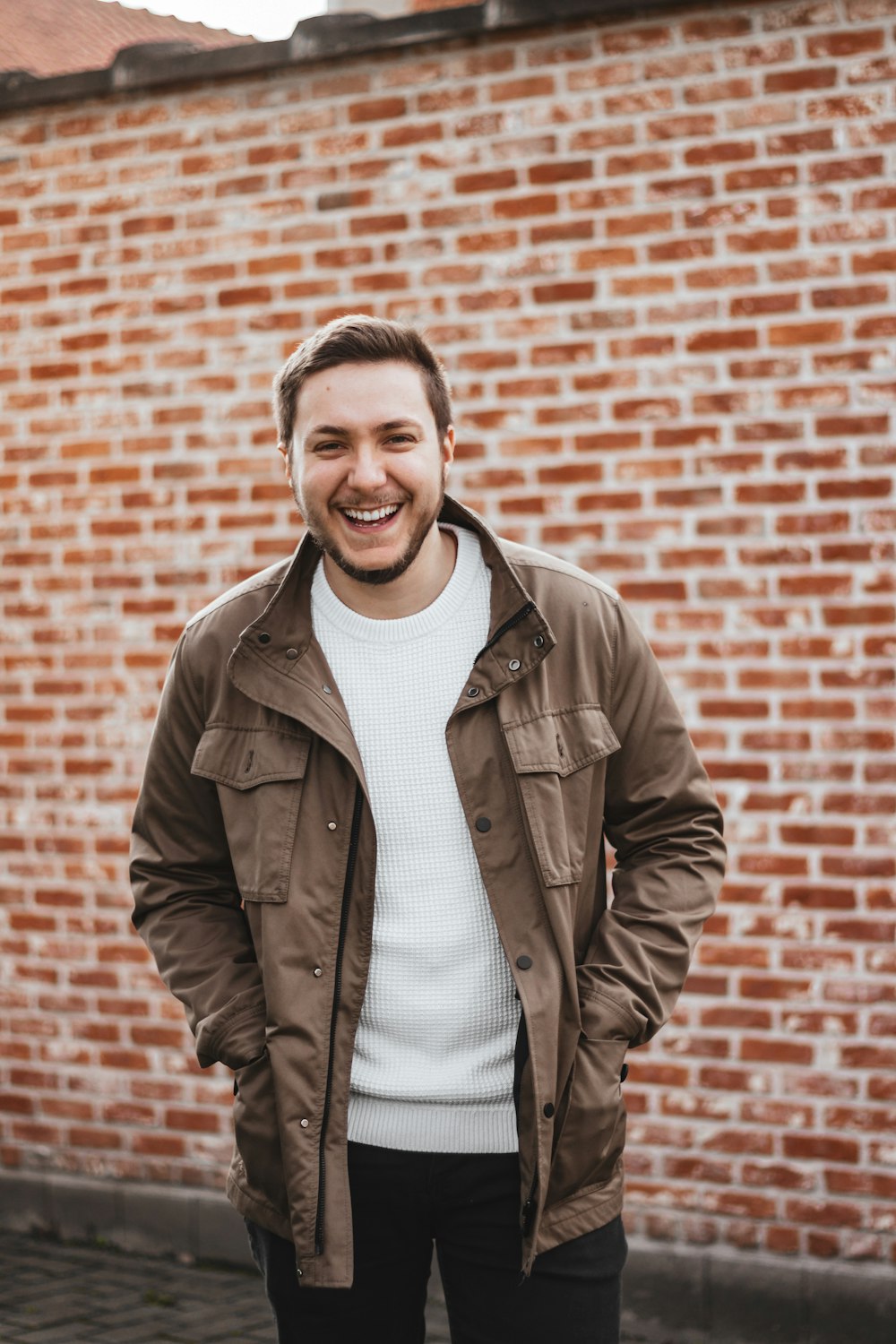 homme en veste en cuir marron souriant