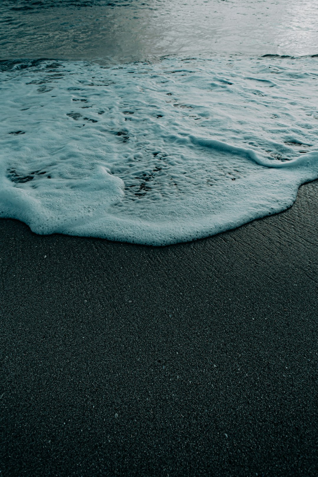 sea waves on black sand during daytime
