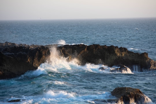 ocean waves crashing on rocky shore during daytime in Algarve Portugal