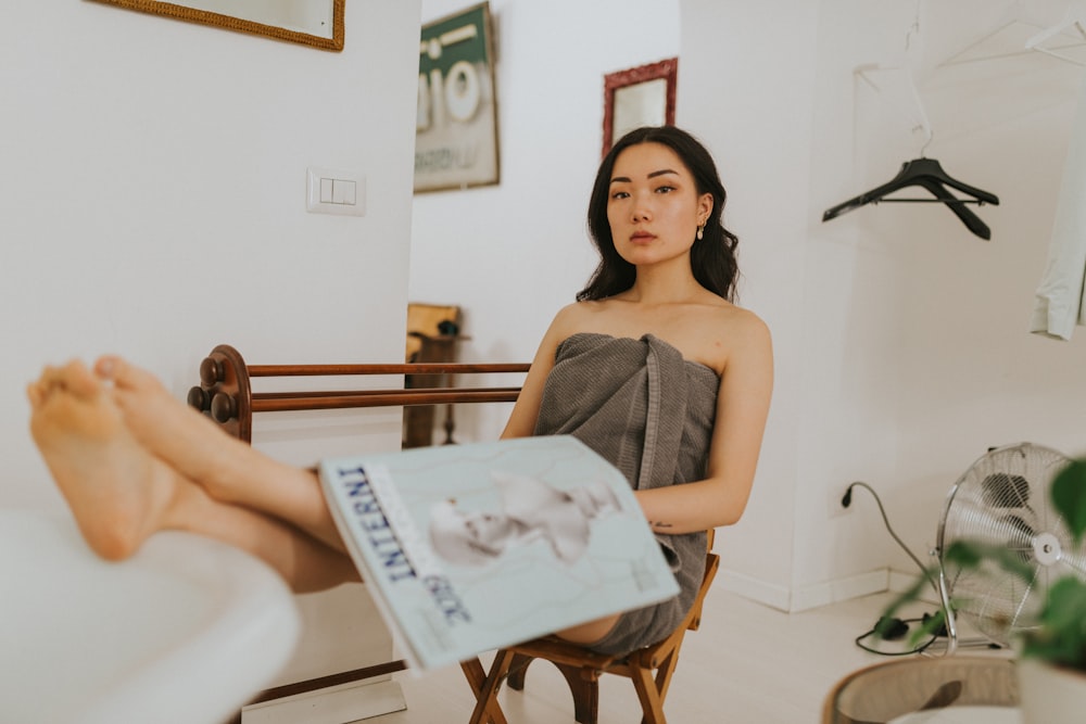 woman in gray spaghetti strap top sitting on white chair