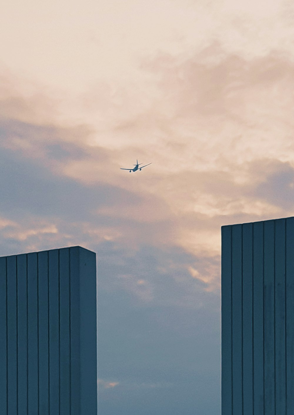 airplane flying over the building during daytime