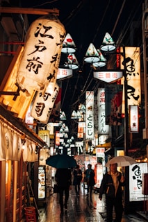 A vibrant street scene in Tokyo with colorful lanterns and bustling crowds at dusk.