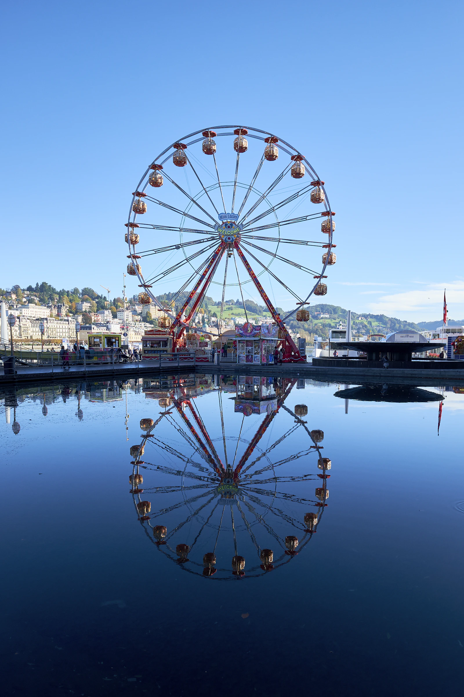 Grande roue au bord de l'eau dans un parc d'attractions