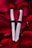 Two silver tubes labeled 'MAXEYLASH eyelash enhancing serum' are nestled amongst vibrant red rose petals.
